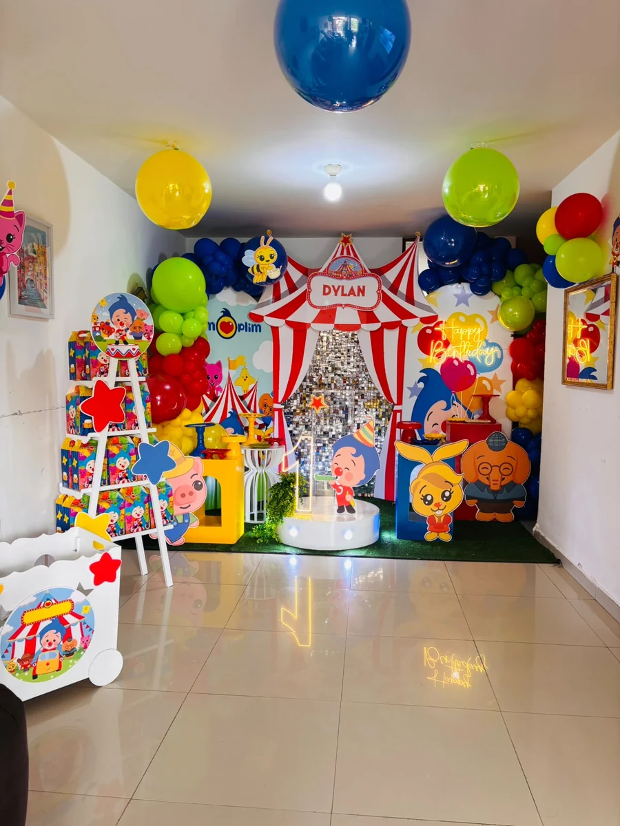 Referencia compartida: montaje de circo infantil con paneles, figuras, mesas y globos de colores