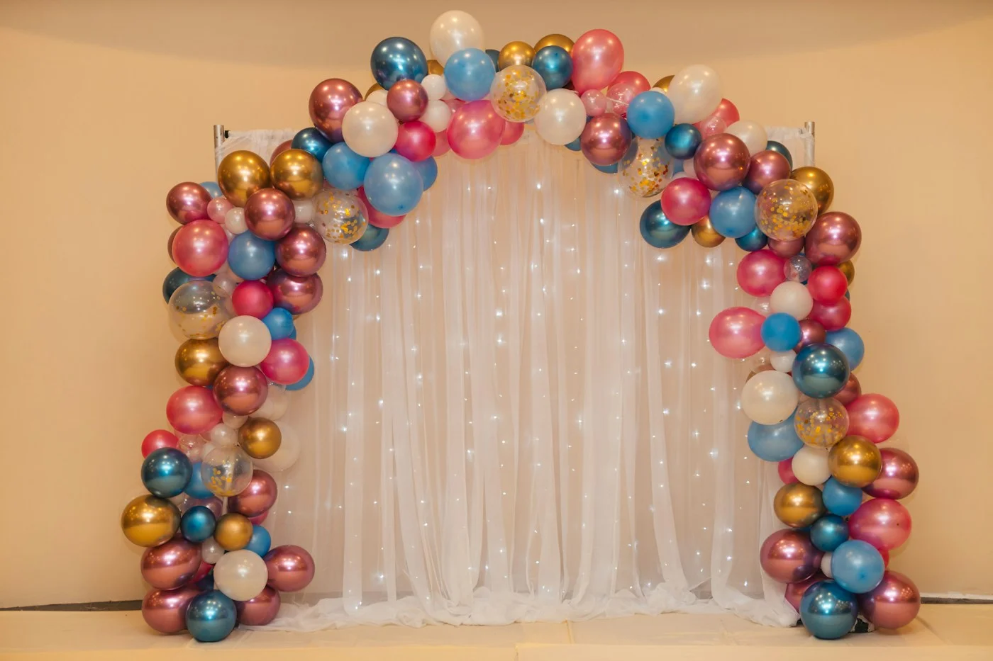 Fotografía de inspiración: arco de globos rosa, azul y dorado con cortina blanca