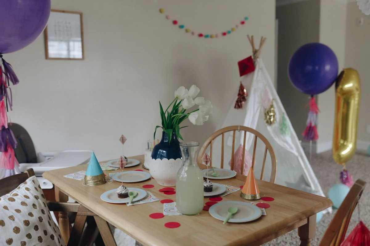 Fotografía de stock: mesa de cumpleaños de madera con tipi, cupcakes y globos